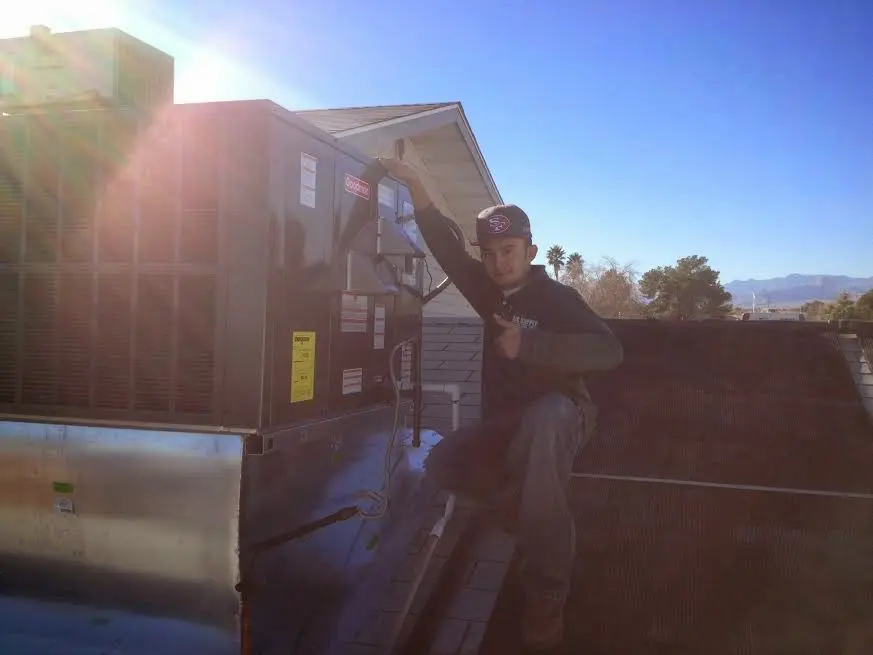 HVAC technician performing HVAC Inspection on a rooftop unit in Sunnyside